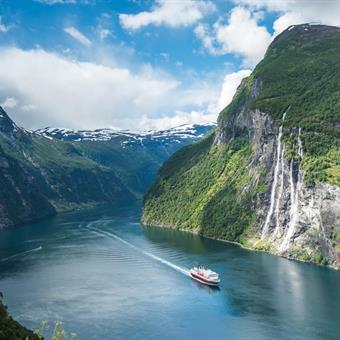 Cruise boat on Geirangerfjord passing Seven Sisters waterfall
