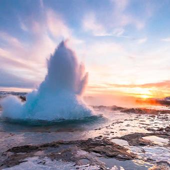 Geysir erupting at sunset